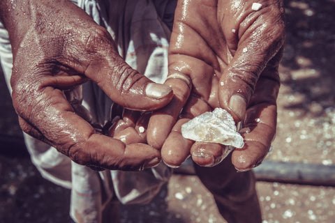 Person holding raw diamond materials out of a mine showing diamond discovery.