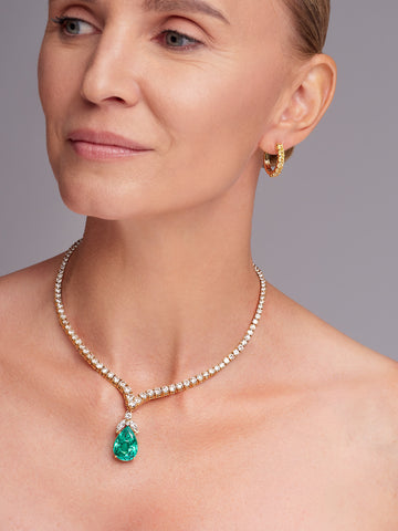 Woman wearing an emerald gemstone pendant necklace