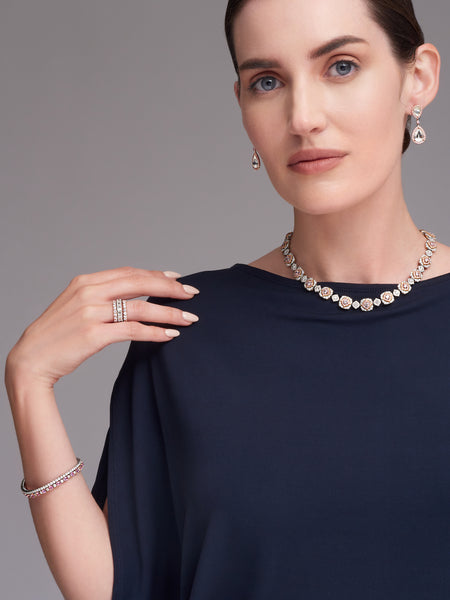 Woman in blue shirt wearing diamond jewelry