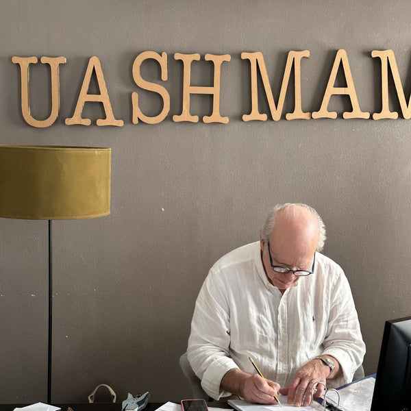 A man is shown working at a desk with the UASHMAMA logo on the wall in the background.