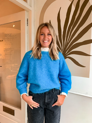 Nat wears the Foubay jumper in Mottled Tropico - a vibrant blue that will keep your look AND mood bright, even on the dreariest of days.