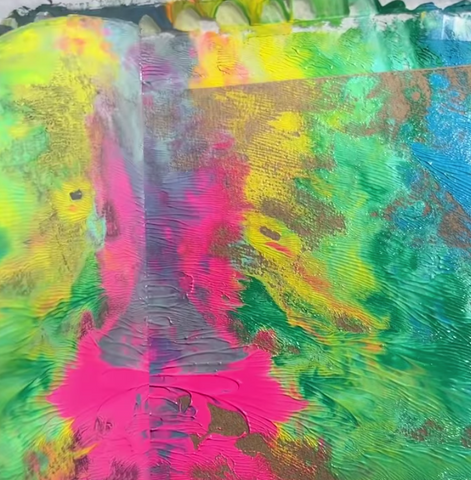 Pink, yellow, green and blue paint on a brown paper folder