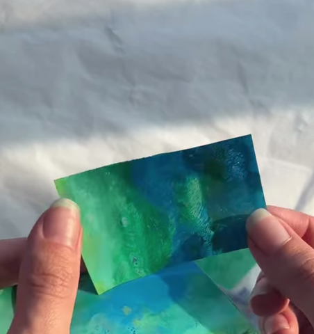 Blue and green paint in a plastic square