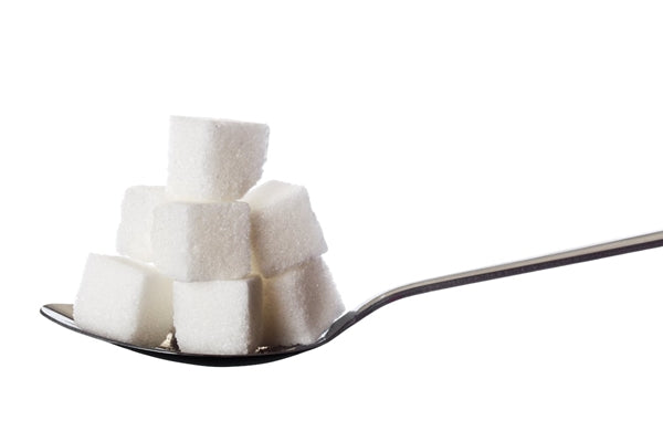 Sugar cubes stacked on stainless steel tablespoon