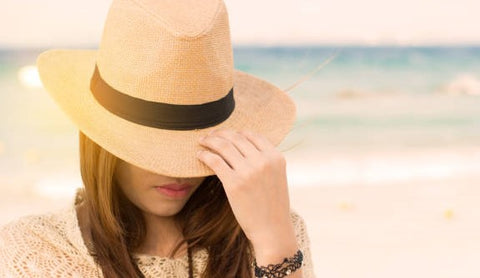 A Woman wearing a Beautiful hat at Beach