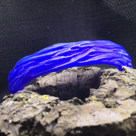 Tree Bark textured bangle carved in blue ferris wax sitting on a log ready to be sent for casting by Kara Jewellery by Charlotte