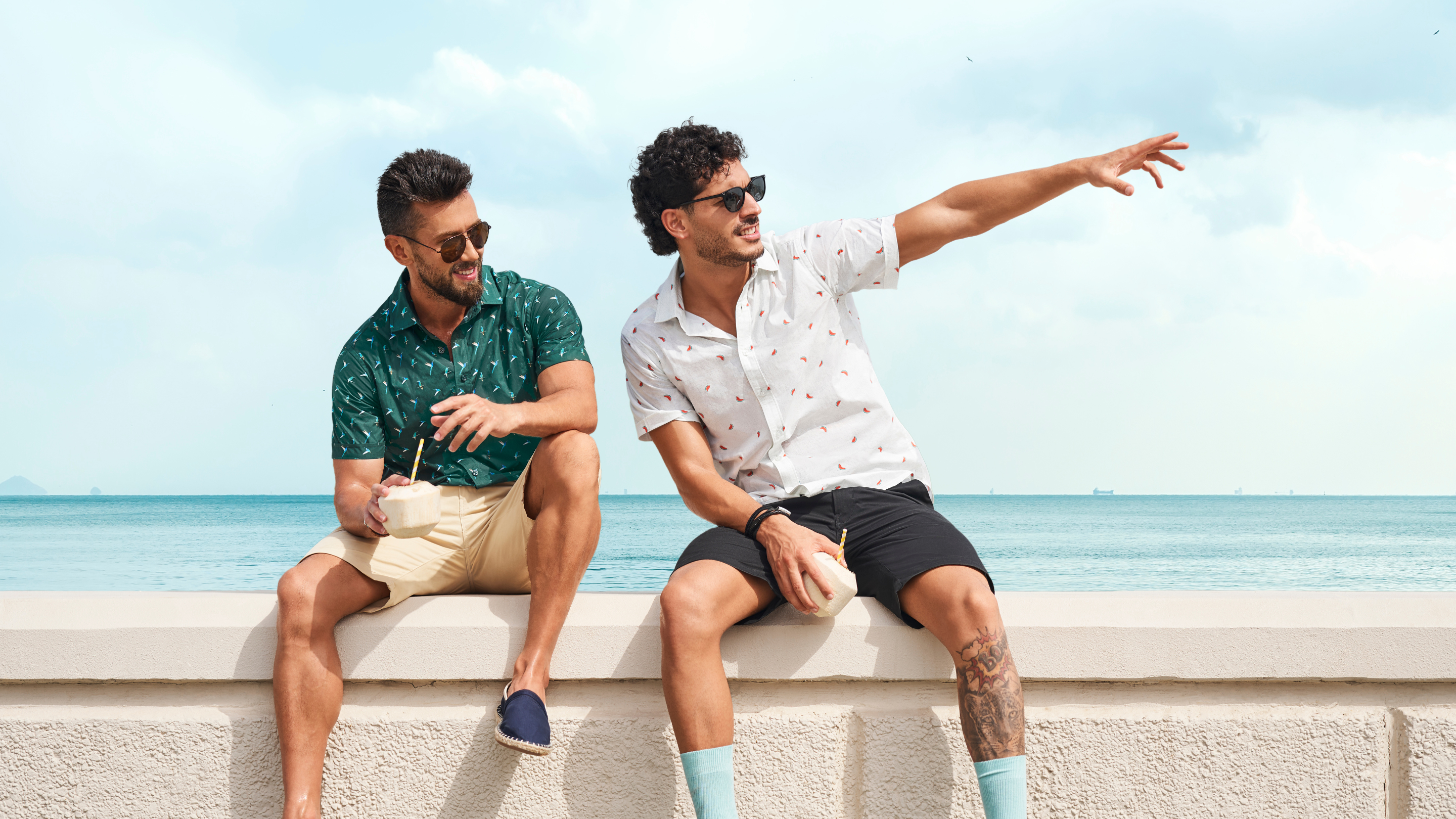Zwei Männer sitzen auf einer Strandveranda und tragen Orabelle-Kleidung
