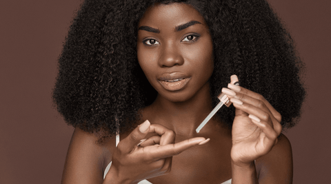 Black woman with natural hair applying Oil in the LCO vs LOC moisturization method.