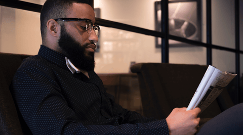 Black man with healthy beard reading a book
