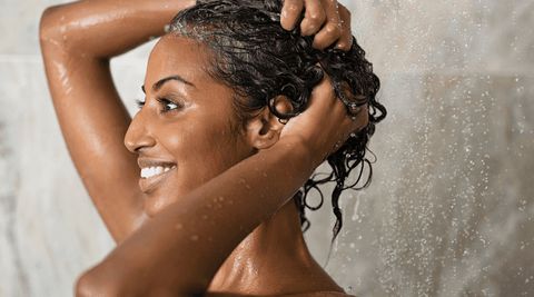 Black woman washing hair with water for LCO vs LOC method.
