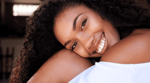 Happy black woman because her natural hair is healthier from using DIY shea butter deep conditioning masque. 