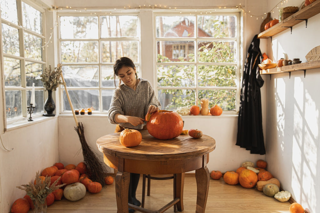 Woman in a brightly lit room with halloween and pumpkin decorations