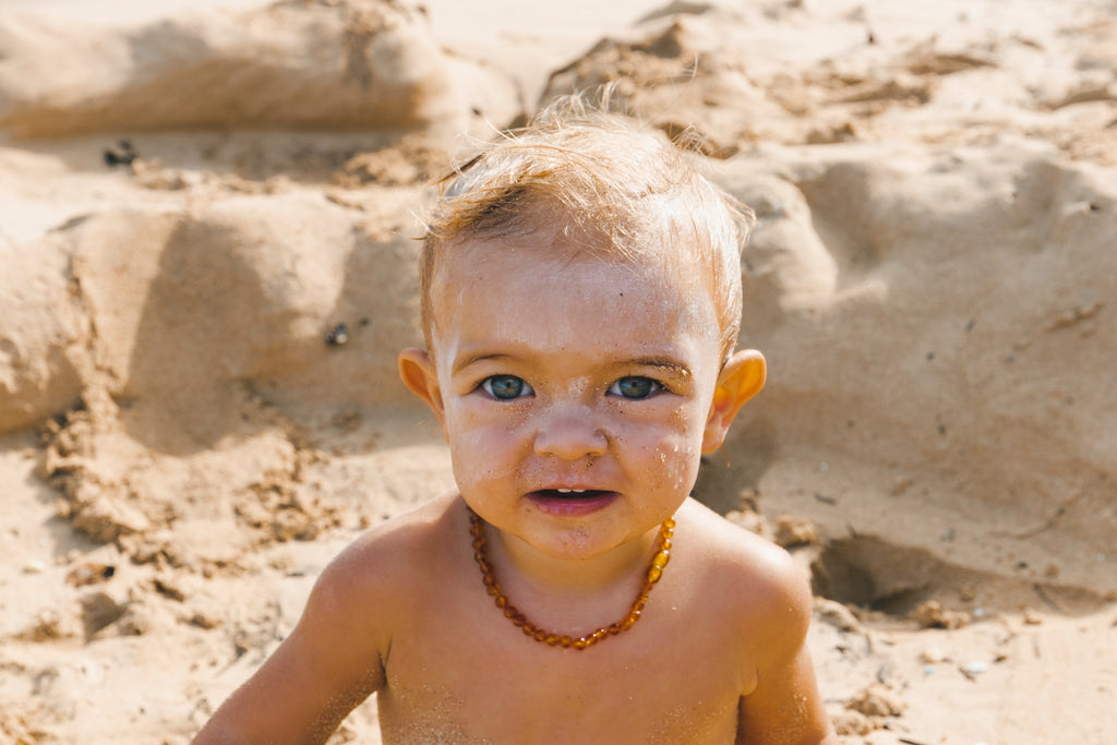 Image of baby on a beach with mineral sunscreen white cast on his face