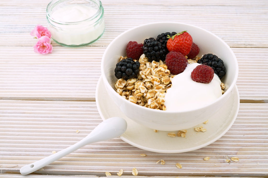 Aerial shot of greek yogurt, berries, and granola on a wooden table