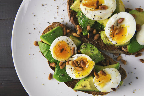 avocado toast with parboiled eggs on top and pinenuts