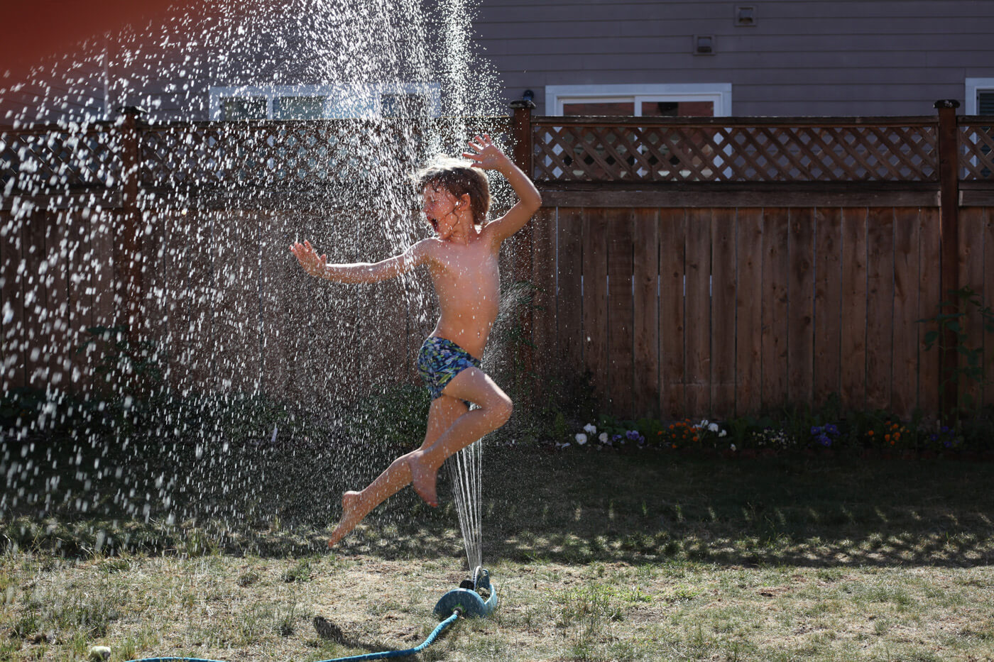 Boy running through the sprinklers