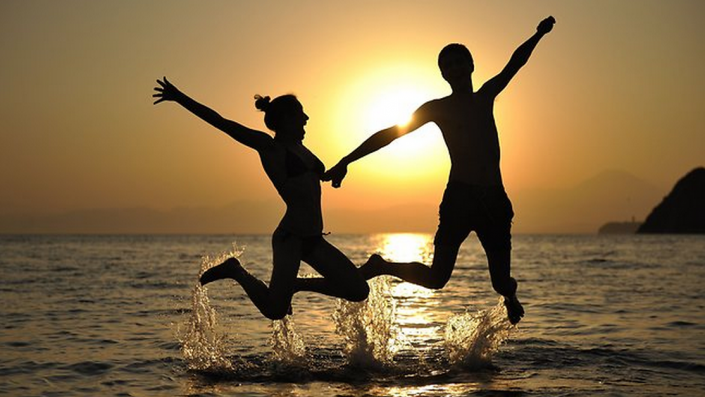 Couple Jumping in the Ocean 