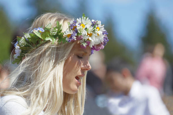 Kukkaseppele juhannusta viettävän naisen päässä