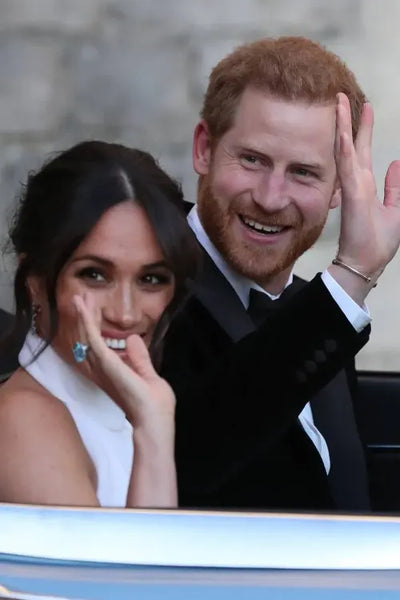 Meghan waving with her blue gemstone ring and Harry