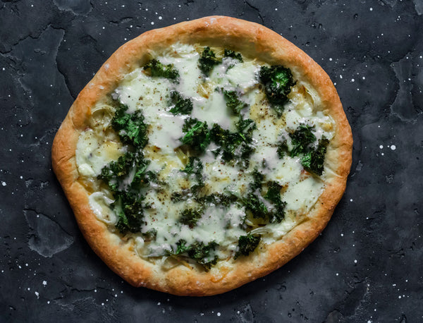 Baked vegetarian potato, kale, mozzarella pizza on a dark background
