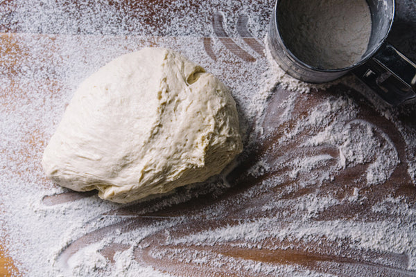 Pizza Dough On A Wooden Surface Dusted With Flour