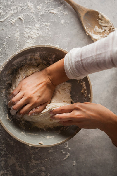 Baker's Hands Kneading Pizza Dough in a Bowl