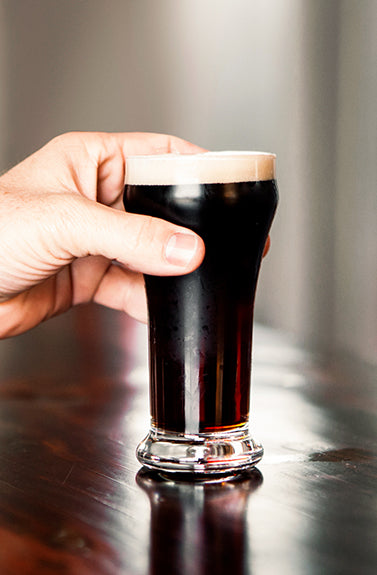 Person holding a glass of beer