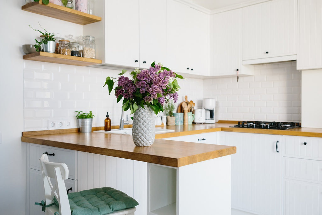 White kitchen with open shelves on the upper bank of cabinets.