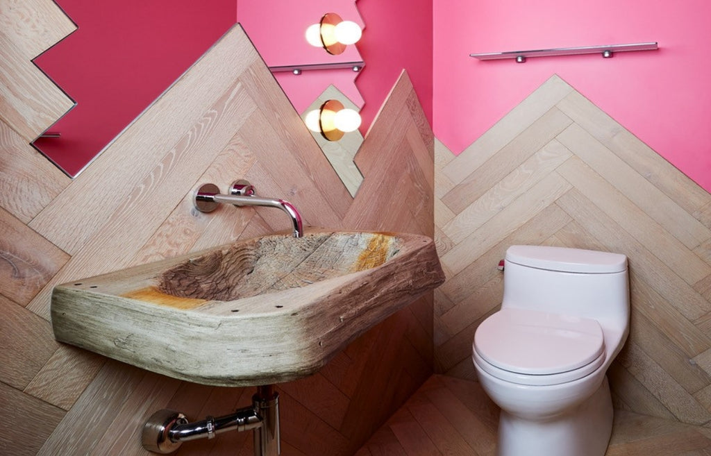 Bathroom sink in concrete that looks like a carved out piece of wood. 