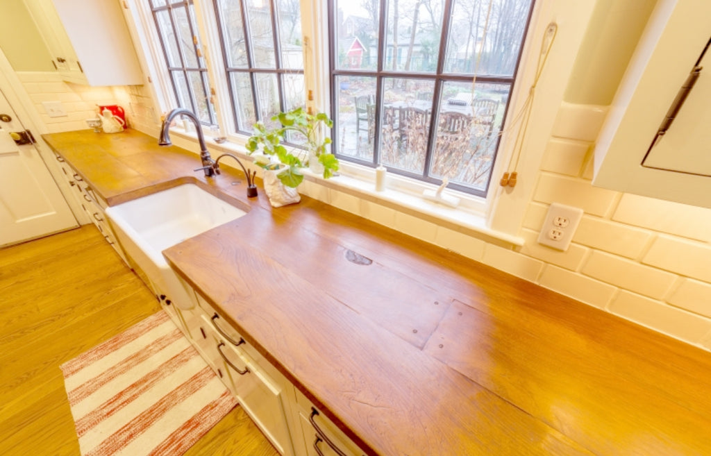 Bright farmhouse style kitchen with wood plank countertops made of concrete.