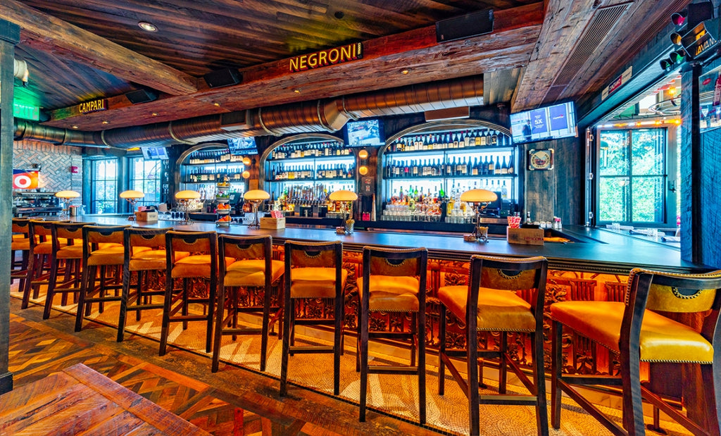 Enjoying a negroni is even better inside Elisabetta's Pizzeria bar area, featuring a Woodform Concrete bar top and ornate woodwork underneath the bar.  