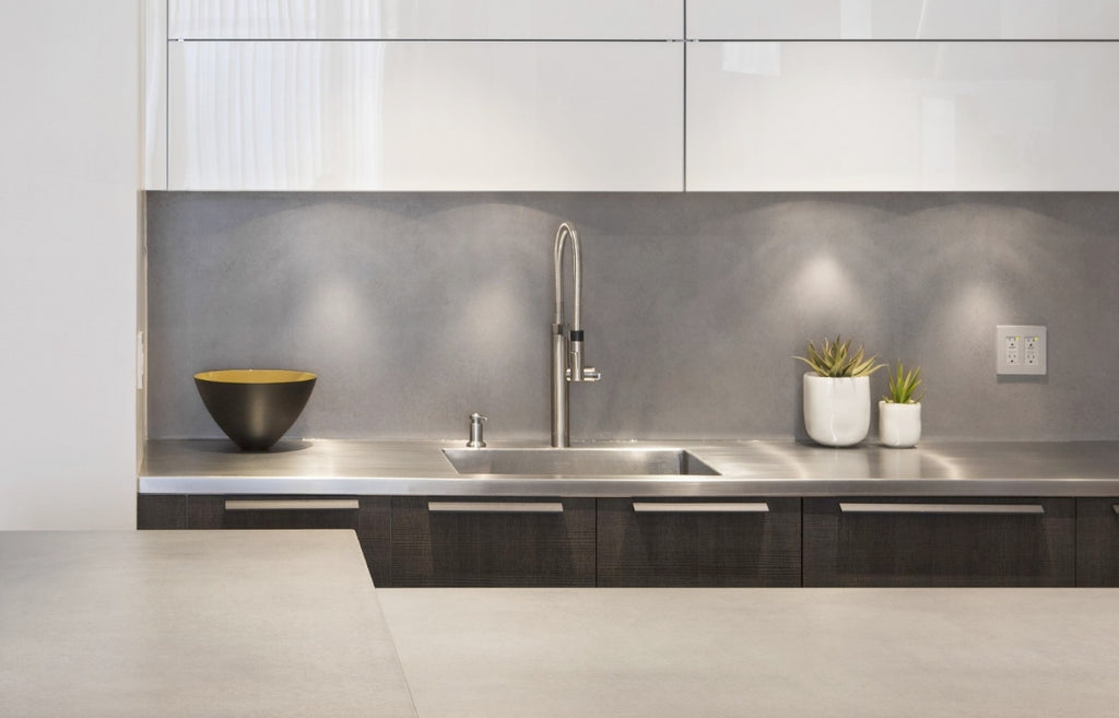 Kitchen with gray concrete countertops and backsplash.