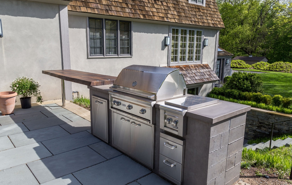 Outdoor kitchen space with a wood look concrete countertop.