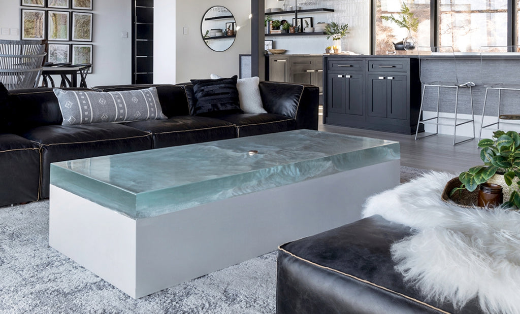 Coffee table in concrete with epoxy top in a large, bright living room.