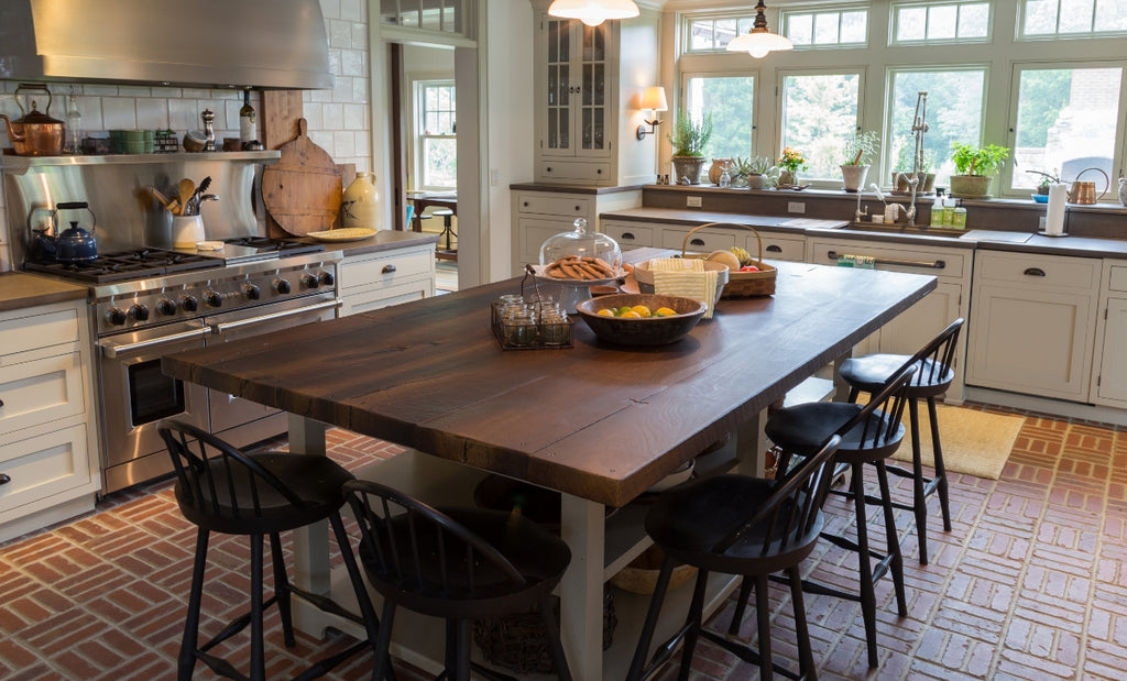 Concrete table that looks like wood in a dark color surrounded by chairs in a cozy environment.