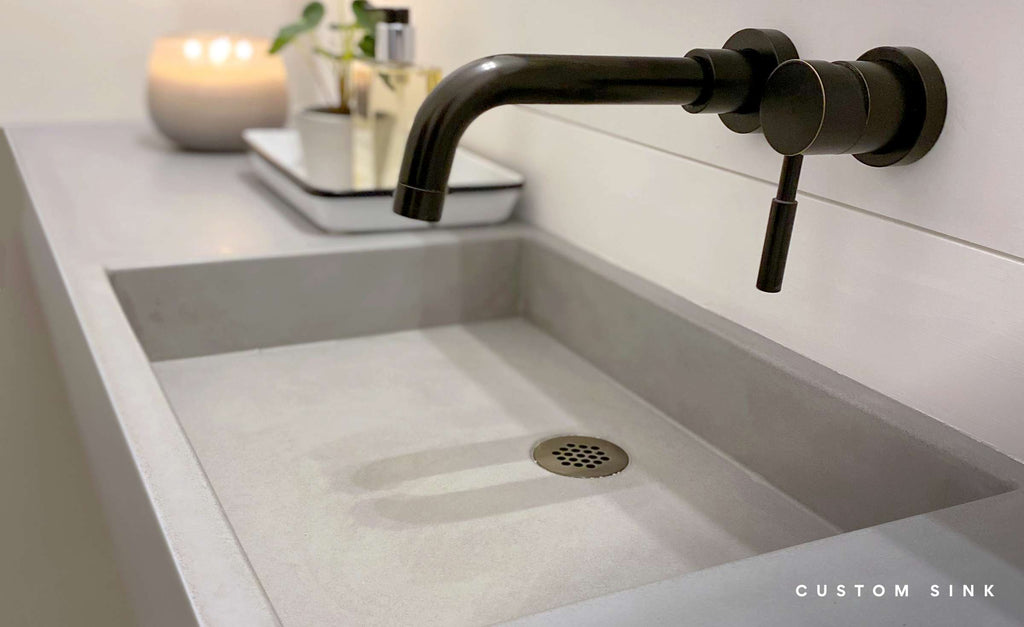 Integrated concrete sink with wall mounted faucet.
