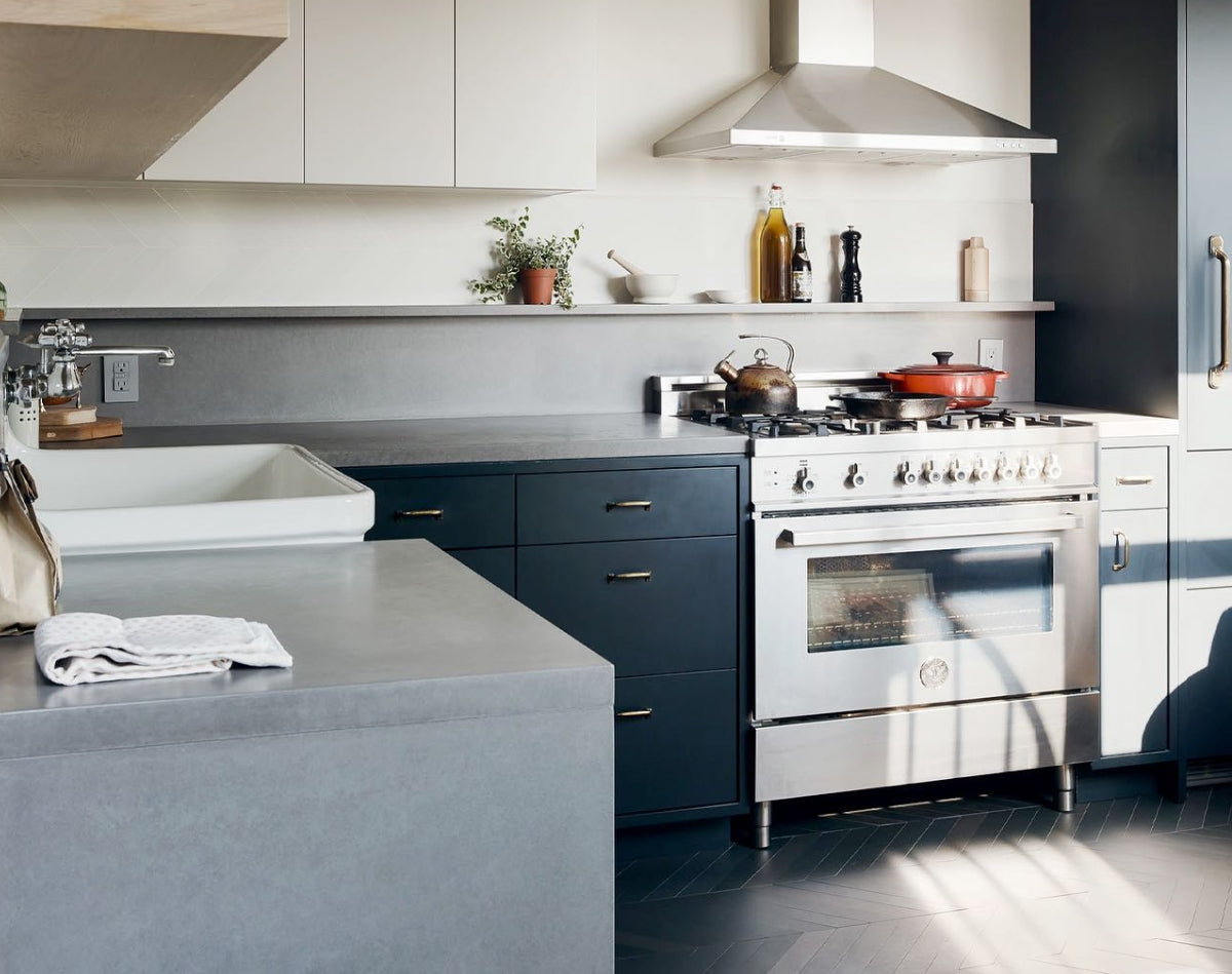Gray, black, and white kitchen with concrete countertops.