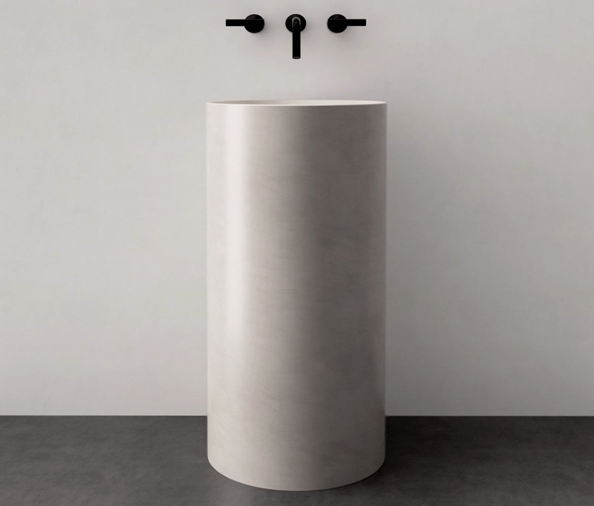 Cylindrical pedestal sink in white concrete.