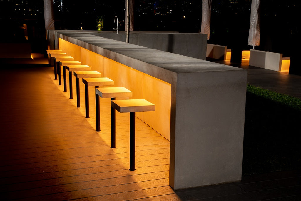 Rooftop concrete bar and concrete bar stools overlooking the NYC skyline.