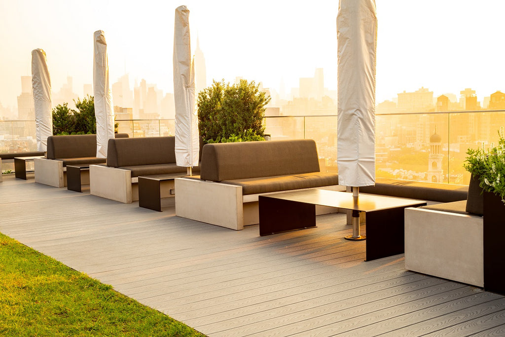 Rooftop outdoor space with concrete bench seating and city view.