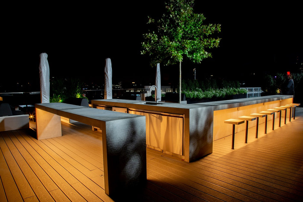 Waterfall concrete countertop island on a rooftop outdoor kitchen.