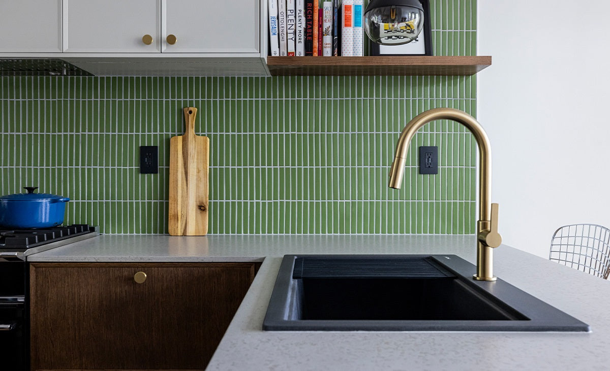 Kitchen with green tiled backsplash and gray concrete countetops.