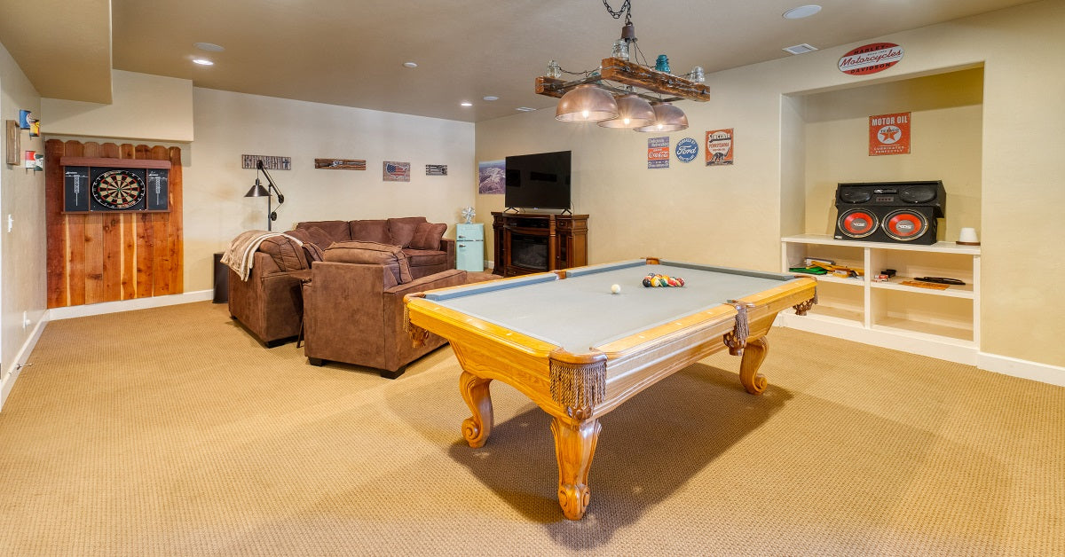 Comfortable basement man cave in beige with overstuffed sofas.
