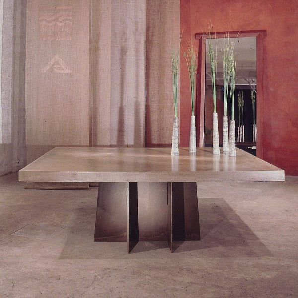 Concrete dining table designed by Clodagh with concrete top and metal pedestal.