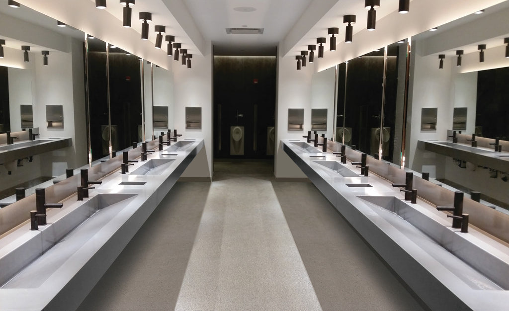 Large commercial bathroom with concrete ramp sinks with several stations each.
