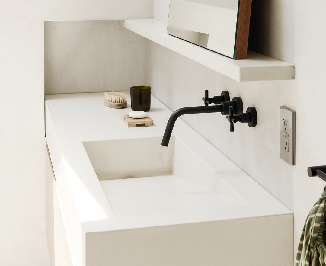 Bright bathroom with white concrete countertops and sink.