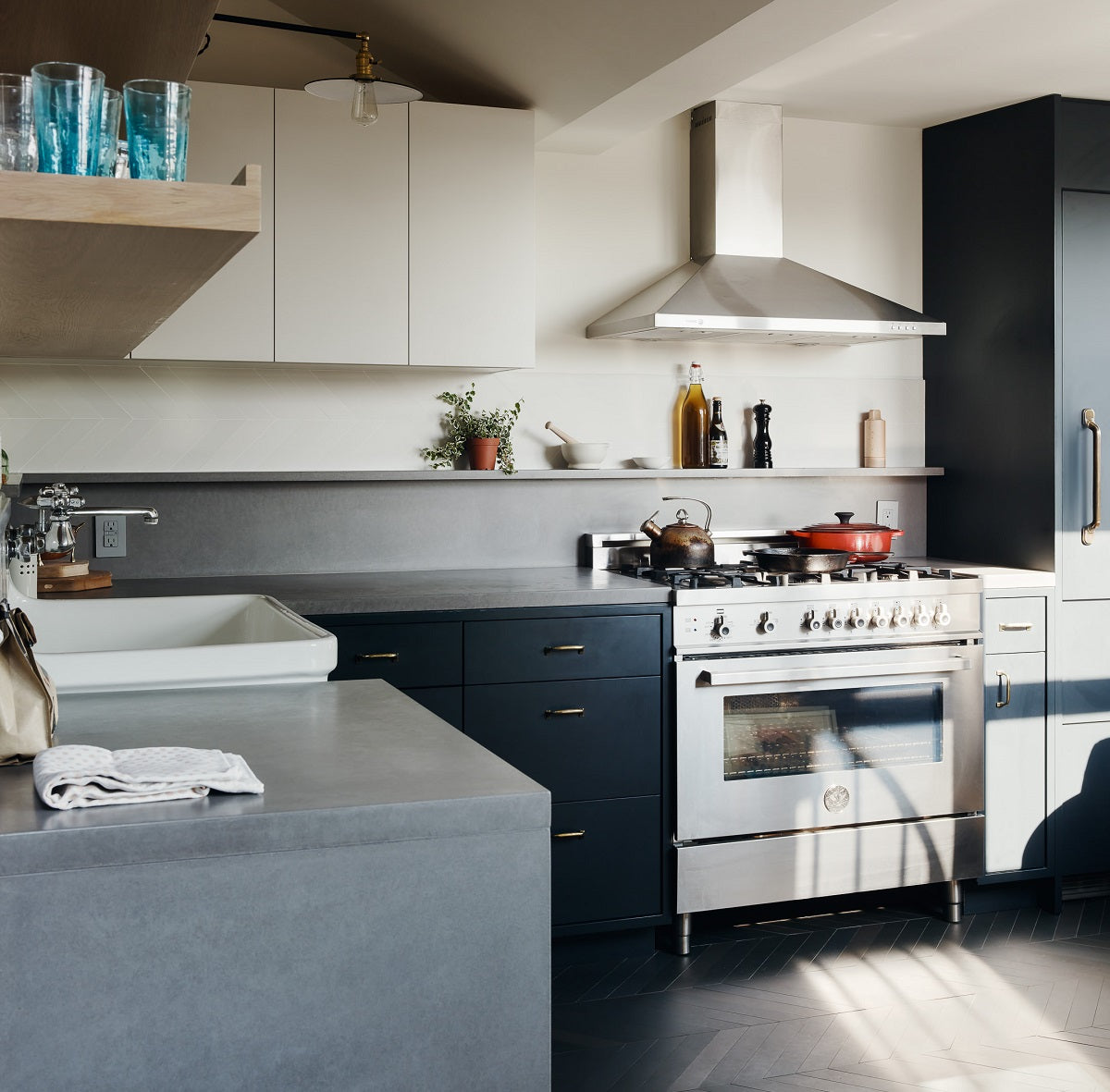 Black and gray kitchen with gray concrete waterfall countertops.