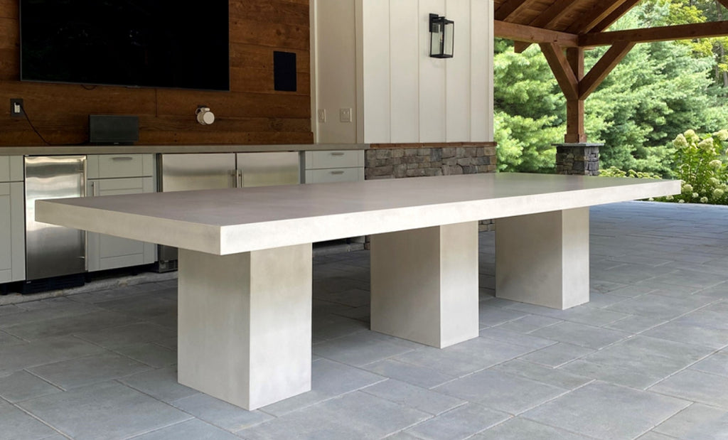 Custom concrete dining table under a patio in an outdoor setting.