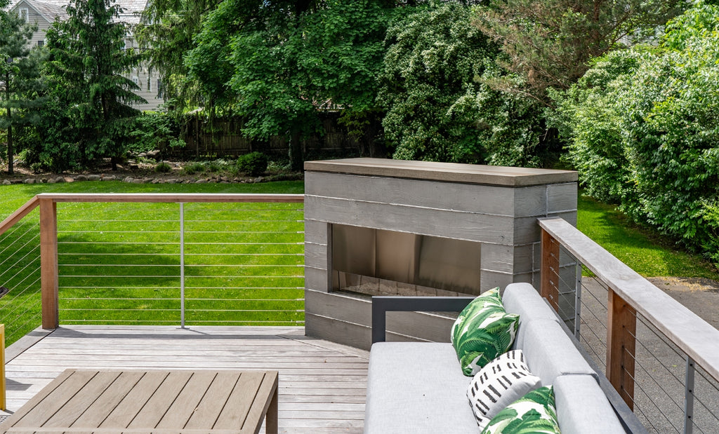 Large outdoor patio with custom concrete fireplace at the corner of the space.