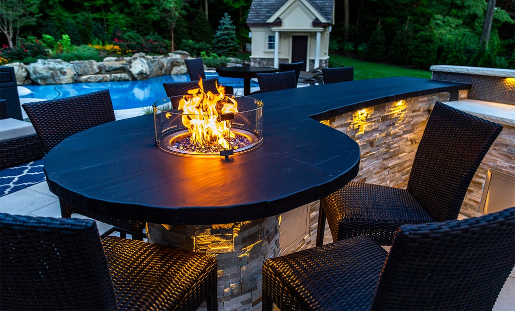 Custom black concrete table with small in-table firepit and chairs surrounding.